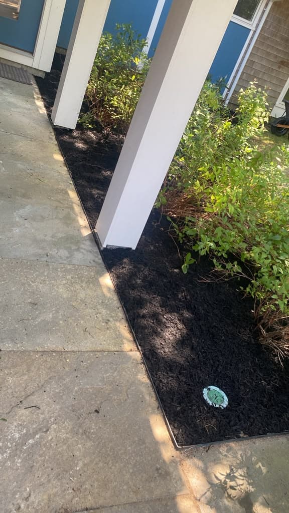 Mulched bed running along the front walkway of a home