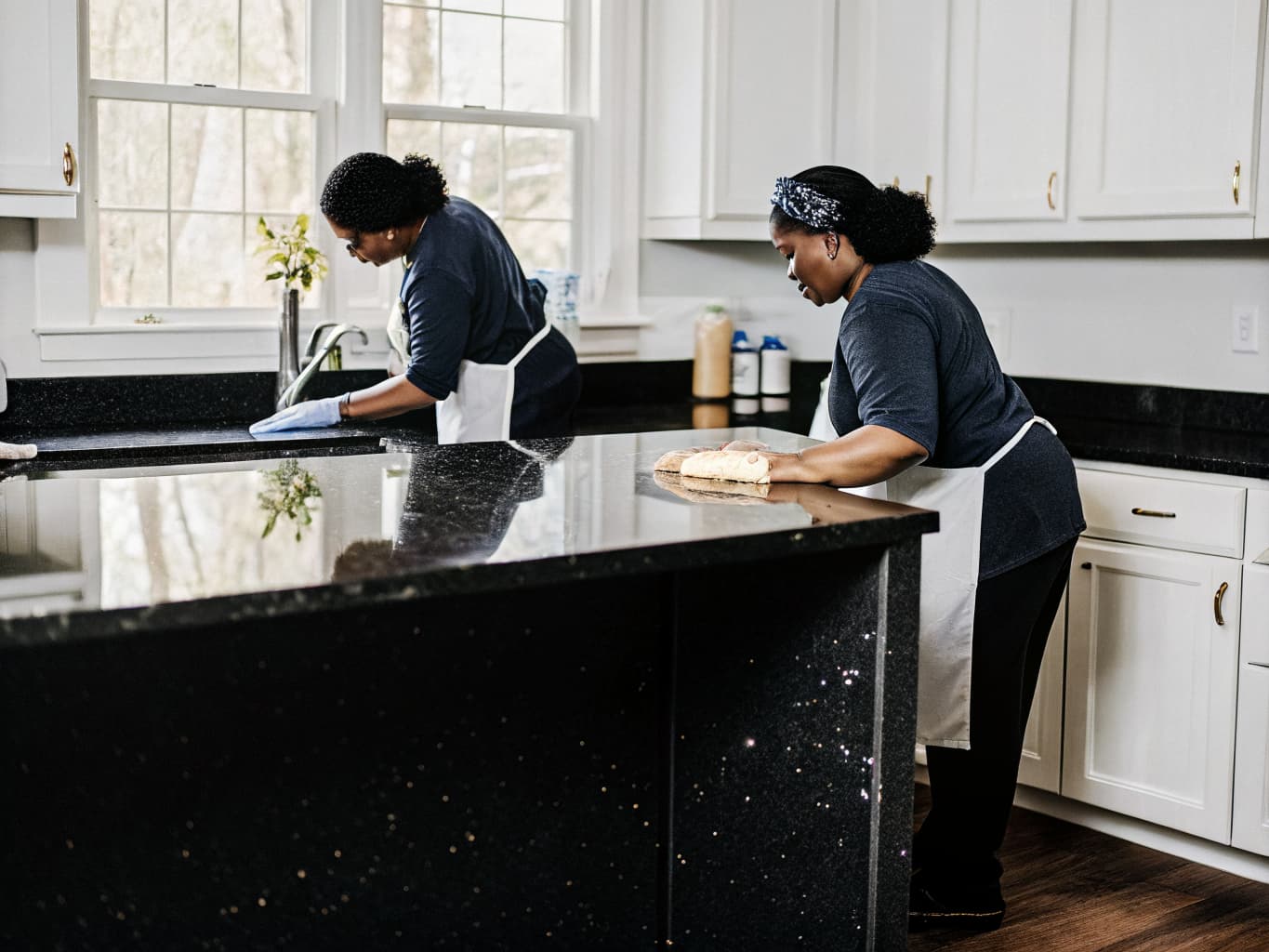 Professional house cleaners working in a Cape Cod home kitchen